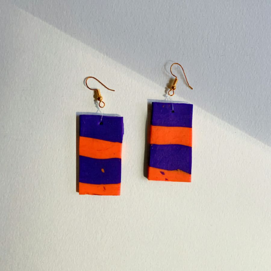 nausnice-bacon-polimerna-glina-histeria.jpg Ručno rađene pravokutne naušnice Bacon od polimerne gline s ljubičastim i narančastim prugama.