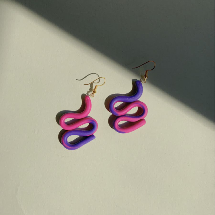 nausnice-snake-polimerna-glina-histeria.jpg Naušnice Snake su ručno izrađene od polimerne gline u ljubičastoj i magenta boji na bijeloj pozadini.